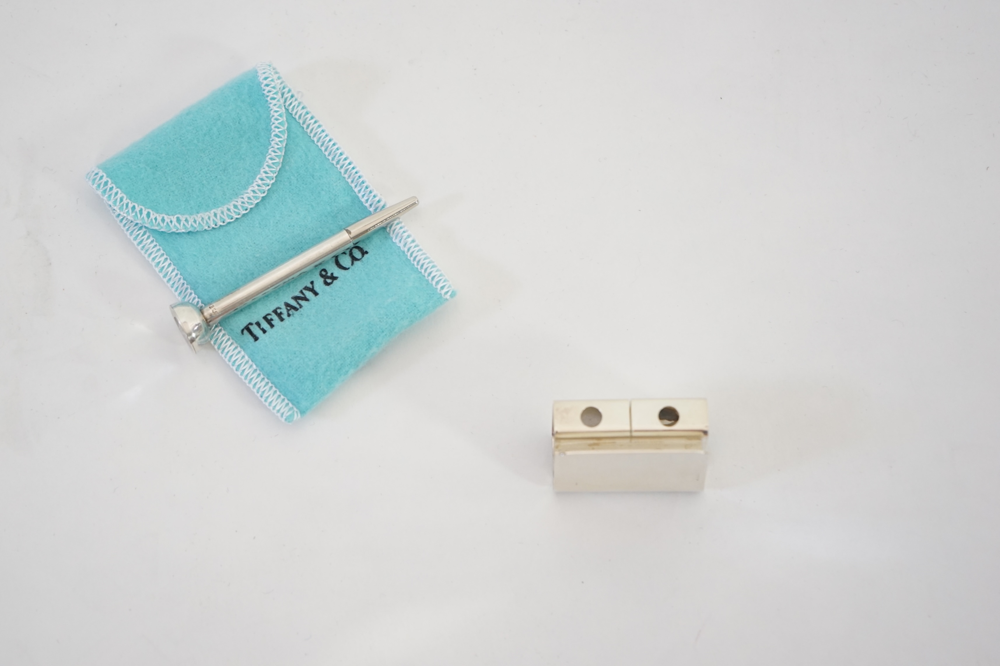 A Tiffany & Co. golf tee holder and pencil